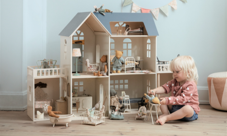 A child playing in front of the Maileg Dollhouse