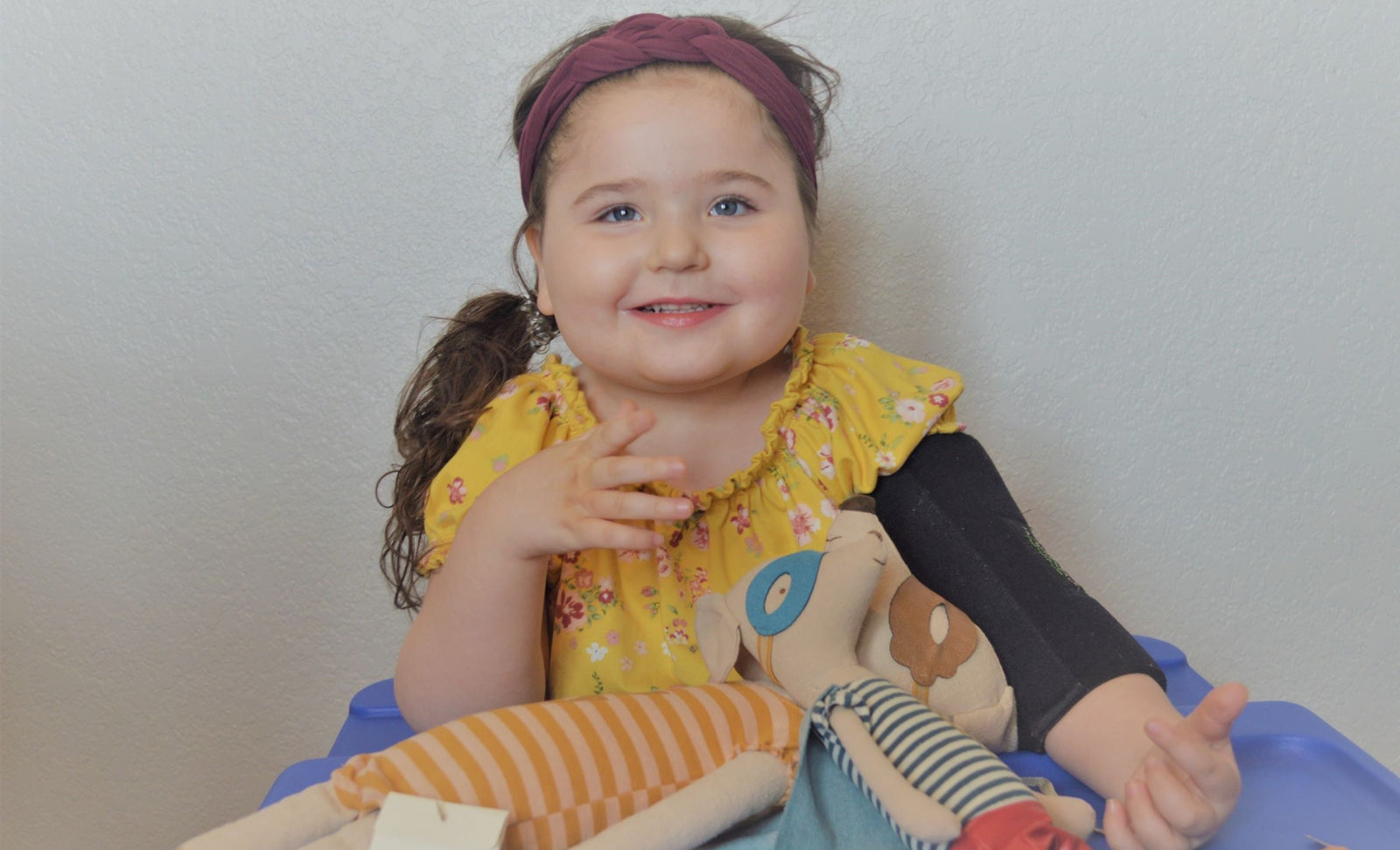 A girl smiling with her Maileg Superhero Mice