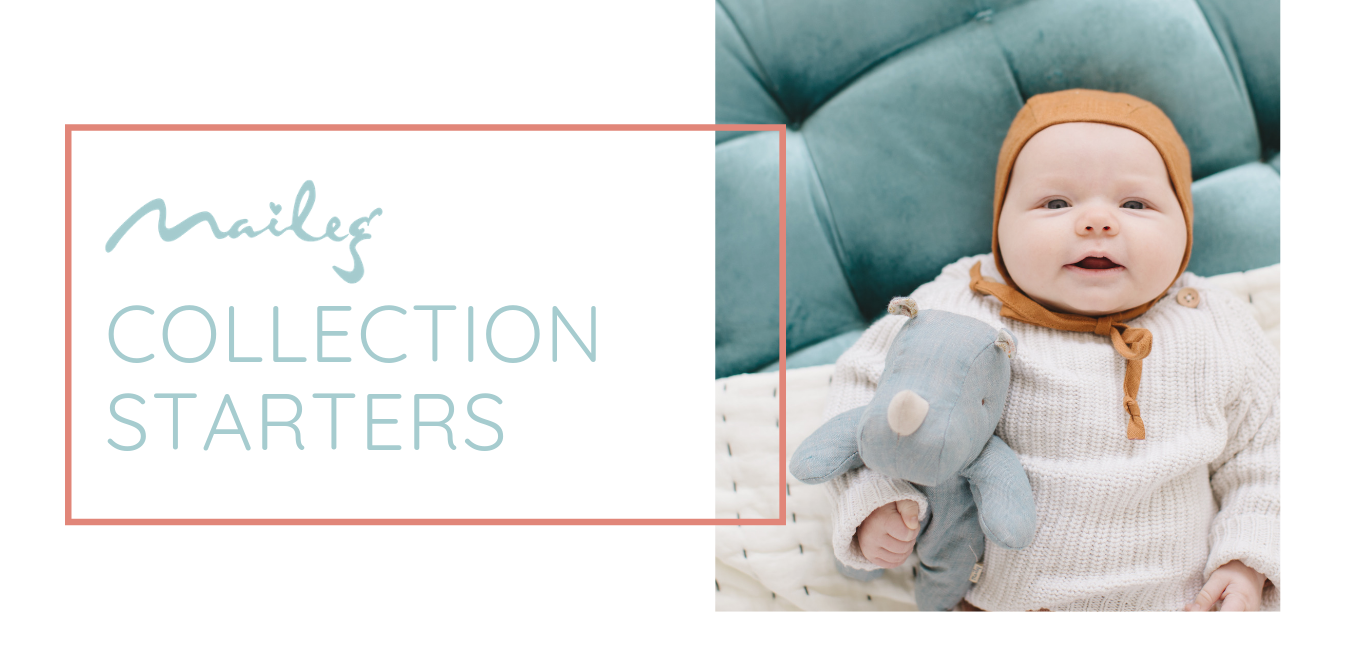 A baby clutching a small Maileg rhino