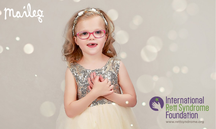 A girl wearing a sparkly dress with her hands on her heart