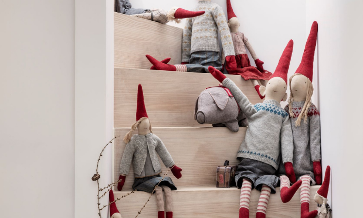 Maileg Christmas pixies in red hats ascending up the stairs