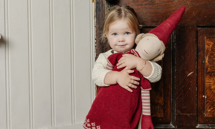 a child hugging a Maileg pixy