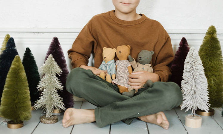 child holding teddy family in arms 