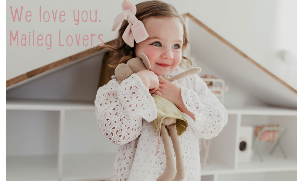 A child hugging the Maileg Medium Mouse in front of a dollhouse